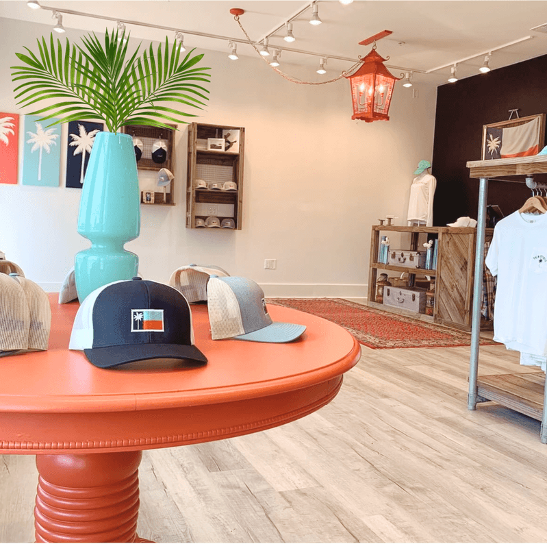The Palm Republic retail interior — flag display, palm-tree-decorated table, branded merchandise