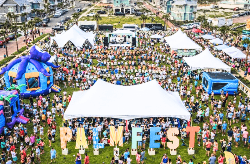 PALMFEST aerial — giant PALMFEST letter installation, crowd, festival tents