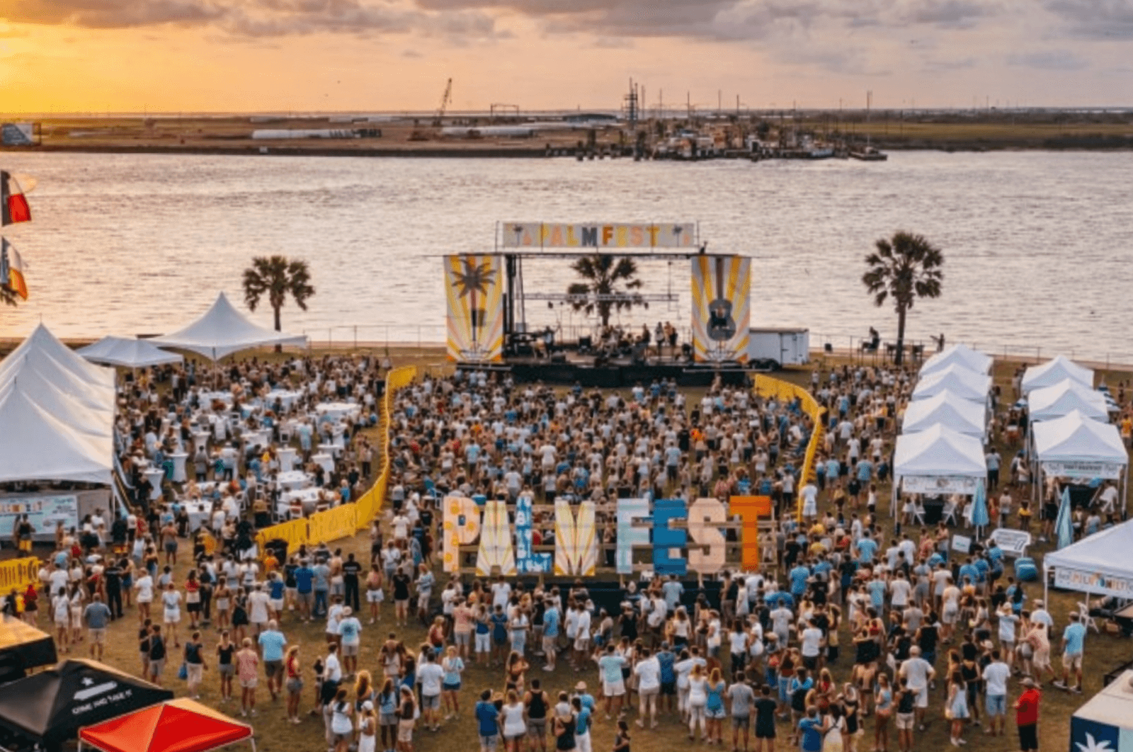 PALMFEST main stage at sunset — crowd, palm trees, festival branding